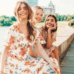 three-beautiful-smiling-girls-trendy-summer-sundress-posing-street